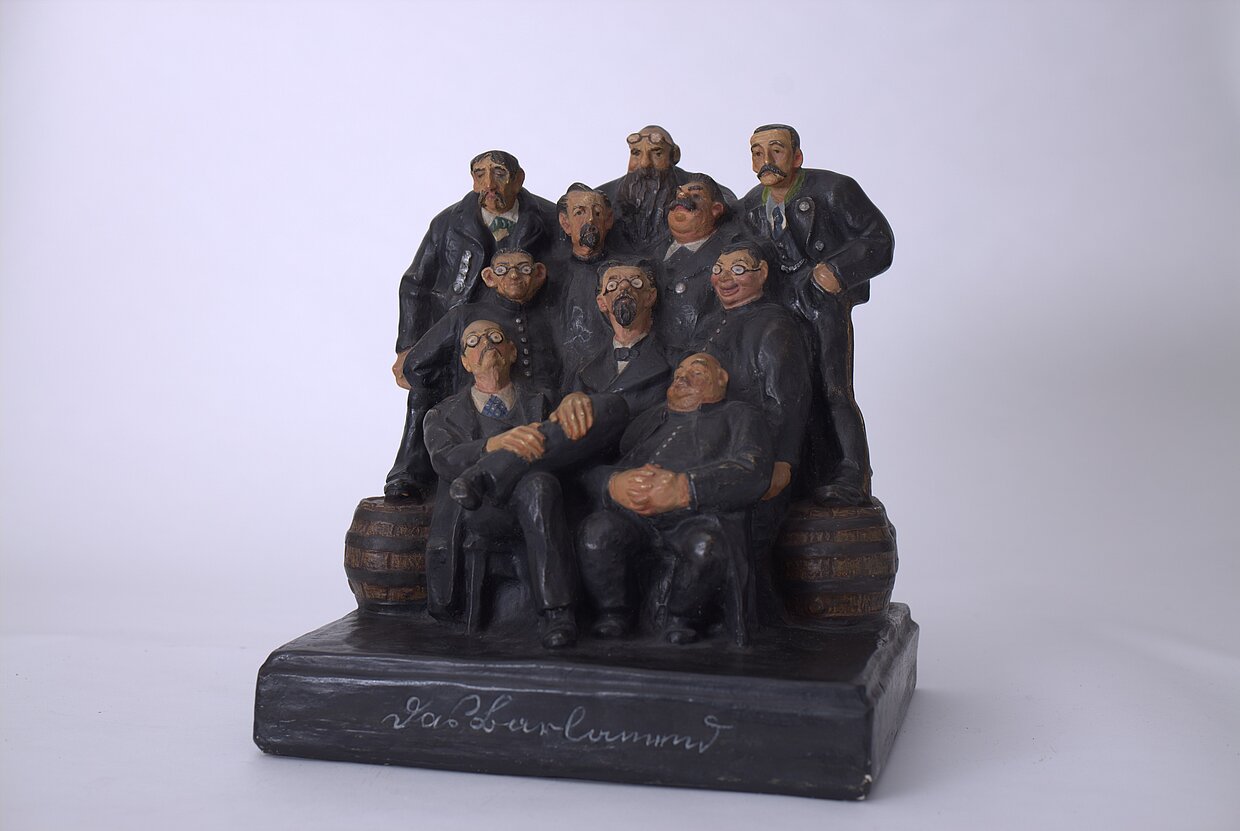 Bayerische Landtagsabgeordnete der Zeit Ludwig Thomas in humorvoller Stammtischpose: Raimund Jäger (1888-1914), „Das Barlamend“, um 1910 © Heimatmuseum Miesbach | Foto: Florian Bachmeier