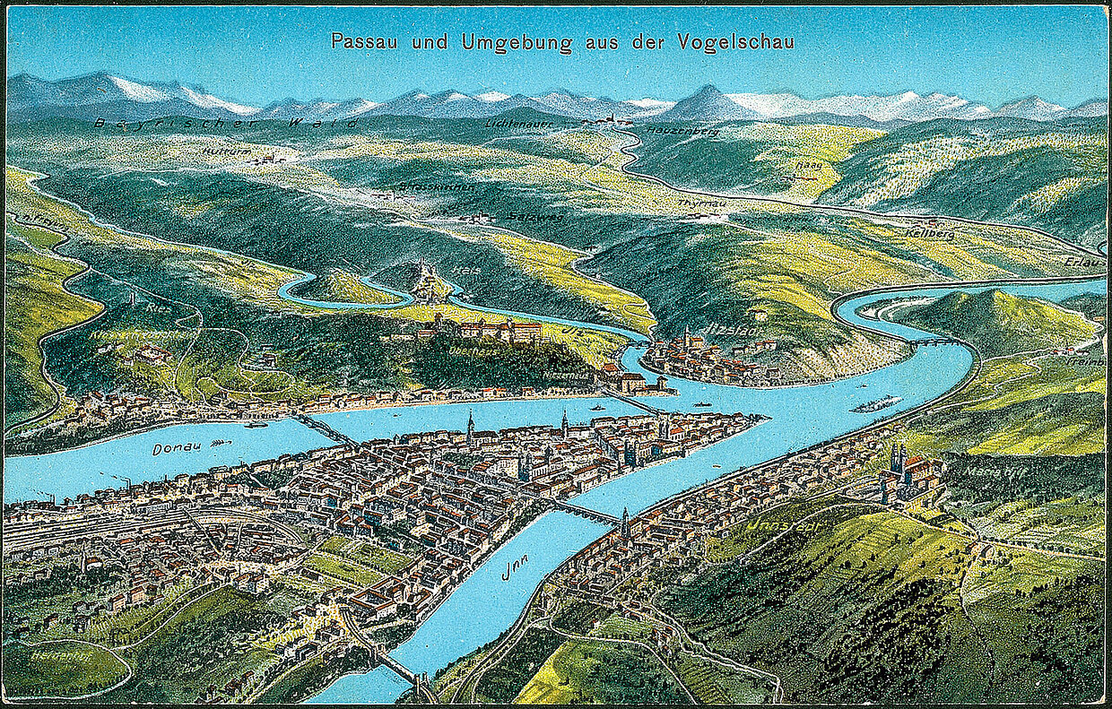Felle, Eugen: Luftbildansicht von Passau und Umgebung, 1913. Die Ansicht aus der Vogelperspektive zeigt die Stadt Passau und die drei Flüsse Donau, Inn und Ilz. Die Ansichtskarte wurde von Eugen Felle (1869-1934) gestaltet. © Haus der Bayerischen Geschichte