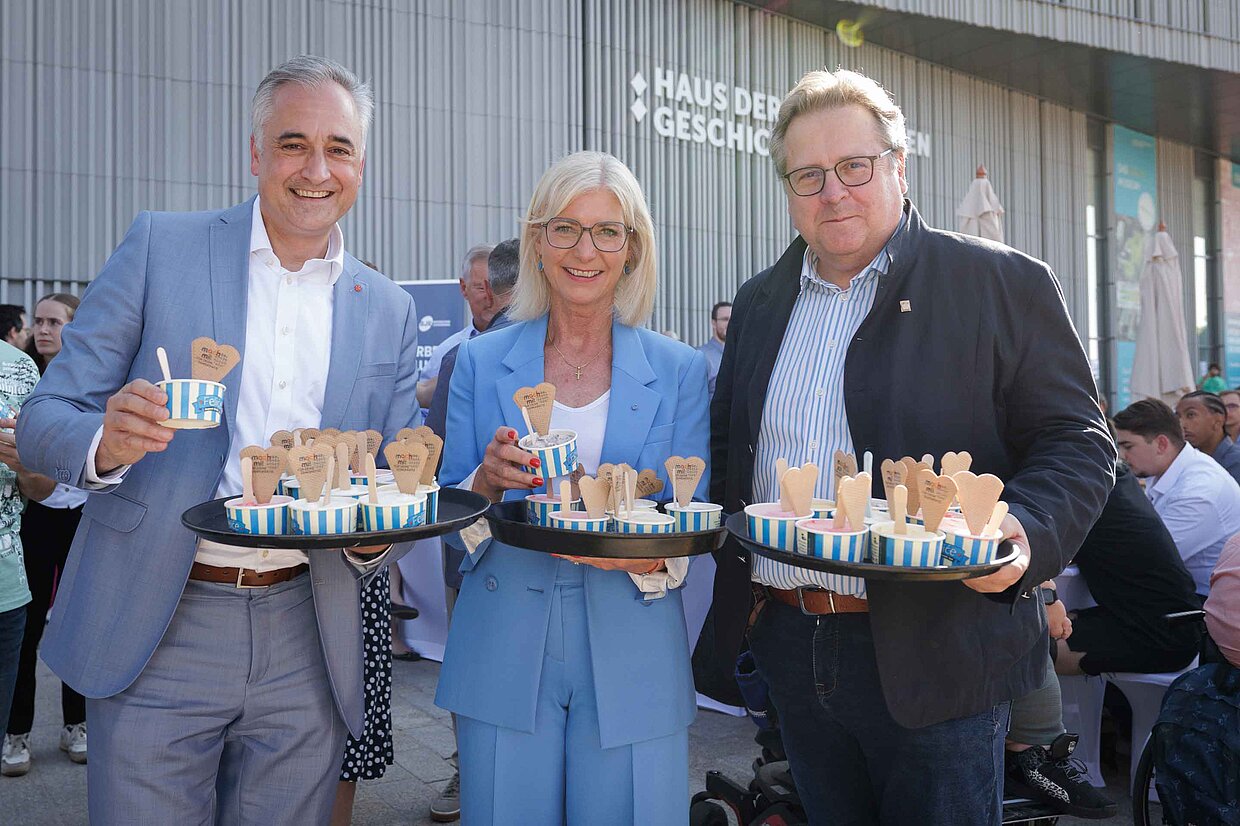 (v.l.n.r.) Regensburgs Oberbürgermeister Dr. Thomas Burger, Staatsministerin
für Familie, Arbeit und Soziales, Ulrike Scharf und der Direktor des Hauses der
Bayerischen Geschichte, Dr. Richard Loibl verteilen bei der Eröffnung des Festes der
Demokratie in Regensburg kostenloses Eis an die Besucherinnen und Besucher © StMAS/Schäffler