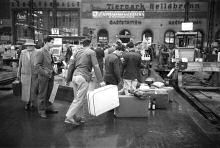 Unbeachtet von einheimischen Passanten bahnten sich die Gastarbeiter mit ihrem Gepäck den Weg durch die Haupthalle des Münchner Hauptbahnhofs (Stadtarchiv München, Archiv Rudi Dix RD0668A03, Juni 1960).
